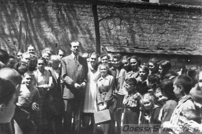 Юрий Тимошенко (Тарапунька), 1955 год
добавил и описал - Jorjic
Те, кто давно живут на свете, может быть помнят, что был когда-то такой популярнейший эстрадный дуэт Тарапунька и Штепсель. Настоящую фамилию Тарапуньки я не помню, а Штепсель был простой одесский еврей Ефим Березин. Оказалось, что учился он (как и ваш покорный слуга) в 36-й школе и в 1955 году посетил со своим партнером родную школу. В то время еще не было кабинетного обучения, и помещения были закреплены за классами, а места в классе - за учениками. И вот оказалось, что мы с Фимой сидели за одной партой и любимый Учитель у нас был один и тот же. Я назову это имя - физик Григорий Александрович Зенкевич. На память от того визита у меня сохранилась фотография. Фимы на ней нет, а над нами возвышается Тарапунька.

